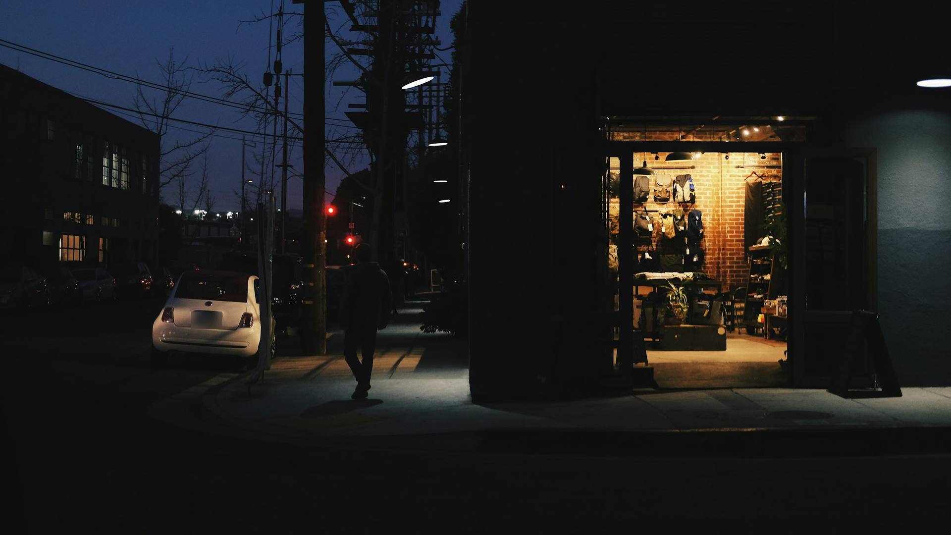 A small shop lit up on a dark street after hours